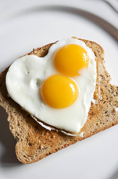 yema de huevo con forma de corazón con - eggs breakfast heart shape fried egg fotografías e imágenes de stock