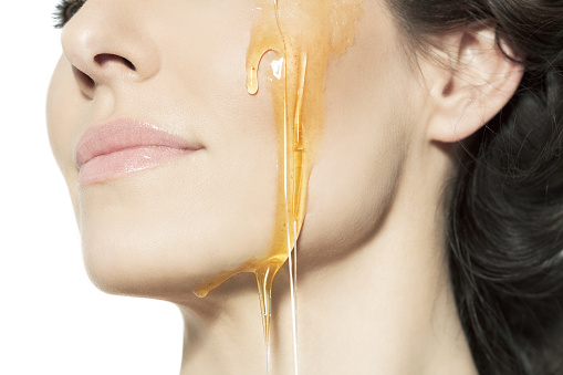 Closeup of a female cheek with honey.