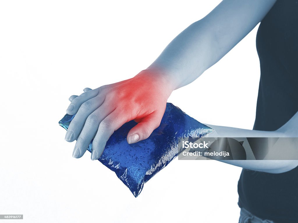 Ice gel pack on a swollen hurting wrist. Cool gel pack on a swollen hurting wrist. Medical concept photo. Adult Stock Photo