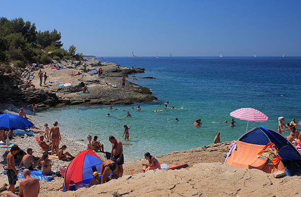Kamenjak,Croatia- August 21,2012: A large group of people, tourists  from  all over  Europe  enjoying sunbathing  and swimming  at Njive beach in peninsula Kamenjak on August 21,2012 on Croatia. Kamenjak is protected nature reserve and  famous tourist destination in Croatia. 