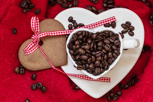 istock Coffee beans in heart shaped cup and dessert on red 483928804