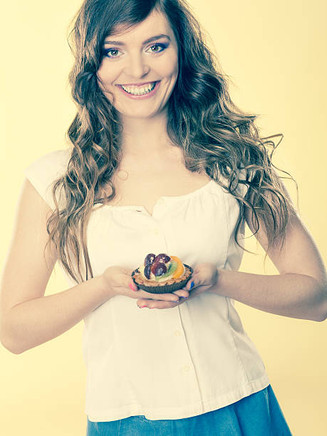istock Smiling cute woman holds fruit cake in hand 483930412