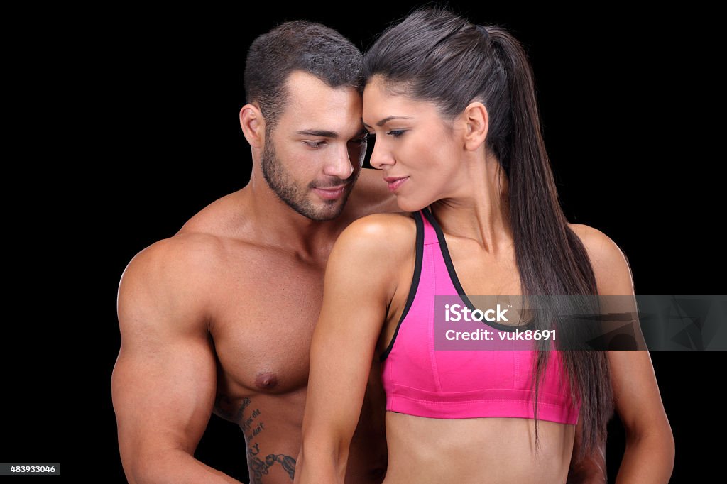 Love Muscular couple in love, isolated on black background 20-29 Years Stock Photo