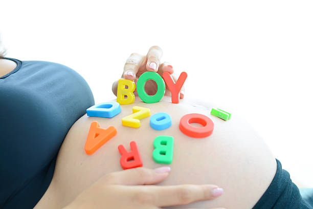 istock Young expectant mother spelling boy on her pregnant belly 483934516