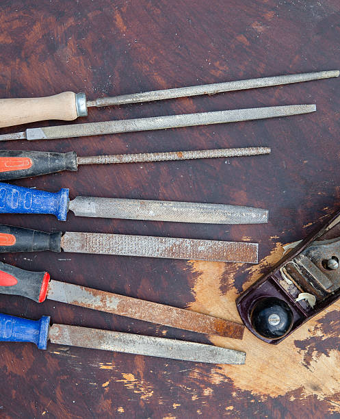 istock Used chisels and a plane on a dark wooden table 483935096