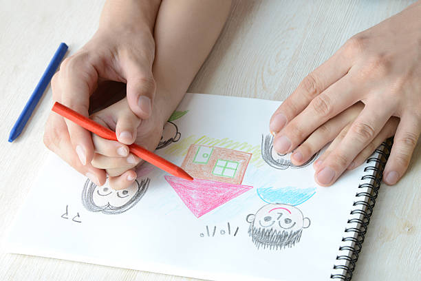 istock Child and mother's hands drawing with crayon 483935822