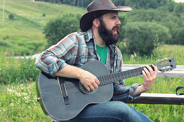 istock guitarist in a cowboy hat on the nature 483940236