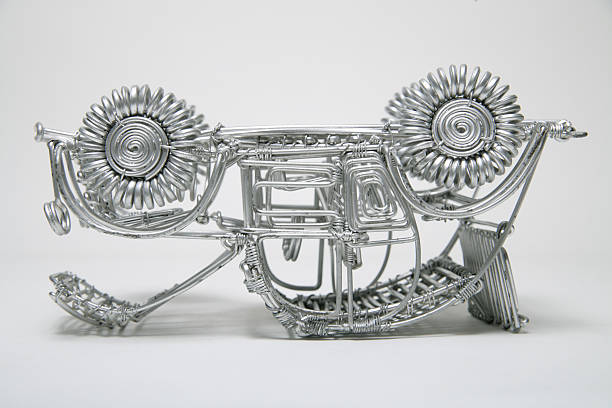 Upside down toy car made of pliable wire against white background,close up