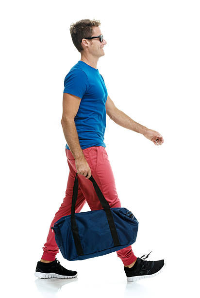 istock Young man walking with gym bag 483944170