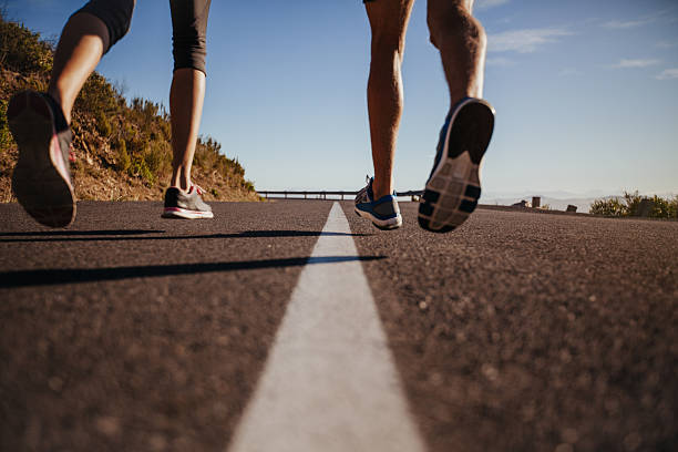 läufer laufen auf der straße - road running stock-fotos und bilder