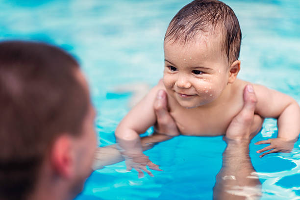 smilling niño bebé en la piscina - bebe bañandose fotografías e imágenes de stock