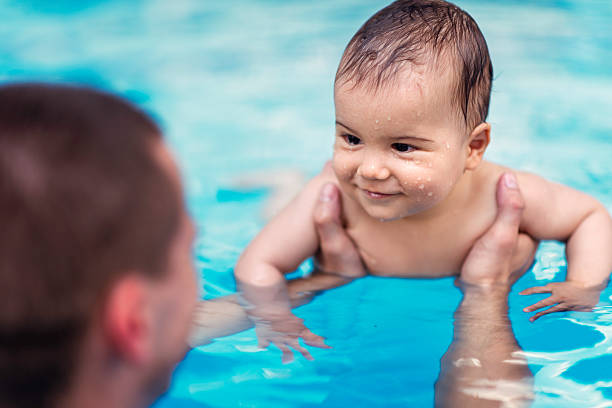 smilling baby мальчик в плавательный бассейн - swimming child swimming pool indoors стоковые фото и изображения