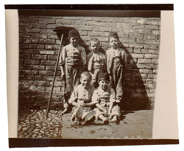Street urchins Vintage photo from the late Victorian early Edwardian period showing a group of poor children on the street.  England. poverty photos stock pictures, royalty-free photos & images