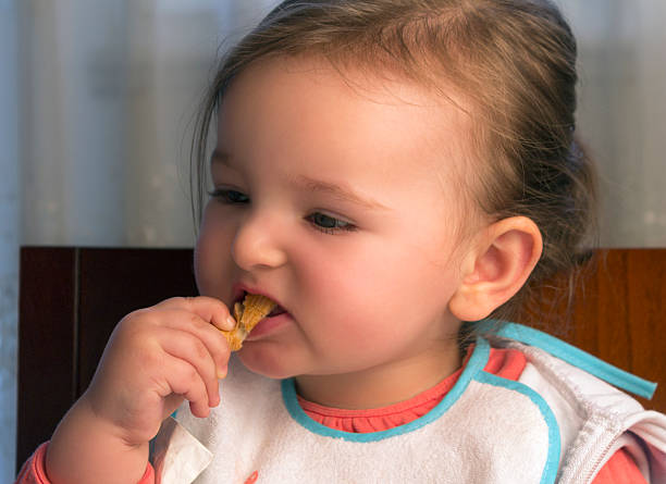 istock Cute baby child eating bread 483954451