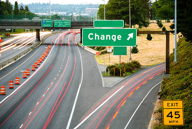 Change: This Way View of a freeway from an overpass at dusk; the word "Change" added in place of an exit name. exit sign photos stock pictures, royalty-free photos & images