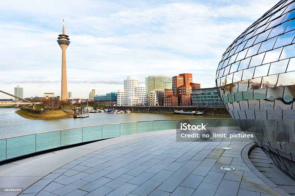 Dusseldorf media harbor Modern office buildings and tower at the media harbor in Dusseldorf. Silver building right in front is the wall from a pub. Düsseldorf Stock Photo