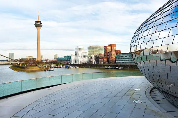 Modern office buildings and tower at the media harbor in Dusseldorf. Silver building right in front is the wall from a pub.
