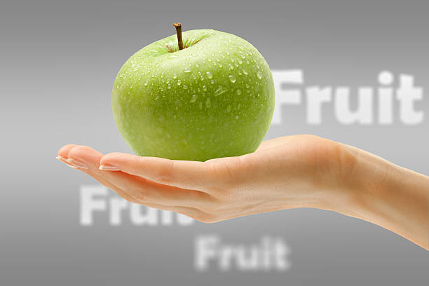 istock Female hand with green apple 483956486