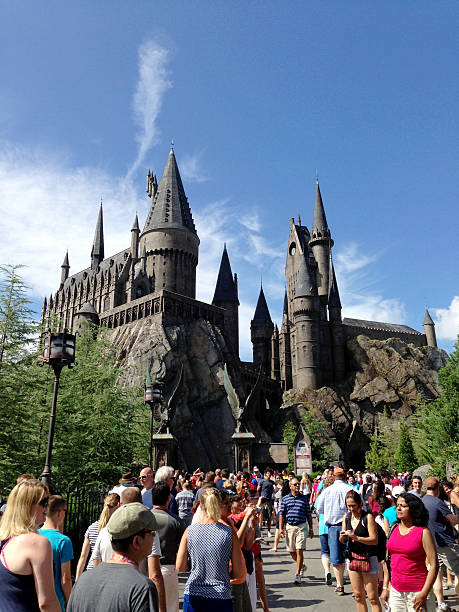 Orlando, USA - August 2, 2013: View of the crowd heading to the very popular Wizarding World of Harry Potter at Universal Orlando resort, the structure resembles the Hogwarts school of witchcraft. Mobilestock image.