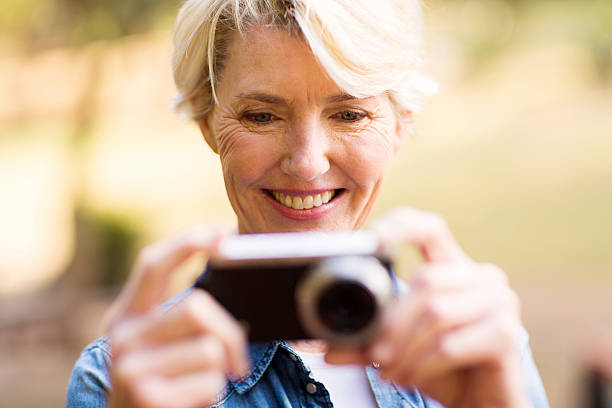 istock middle aged woman viewing pictures on camera 483959284
