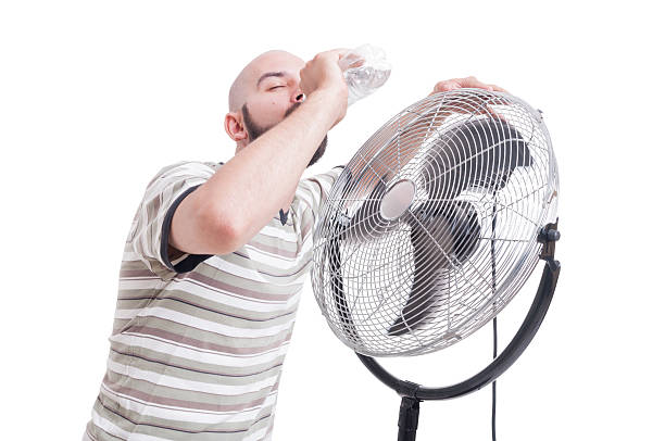 istock Man drinking water near blowing fan 483960470
