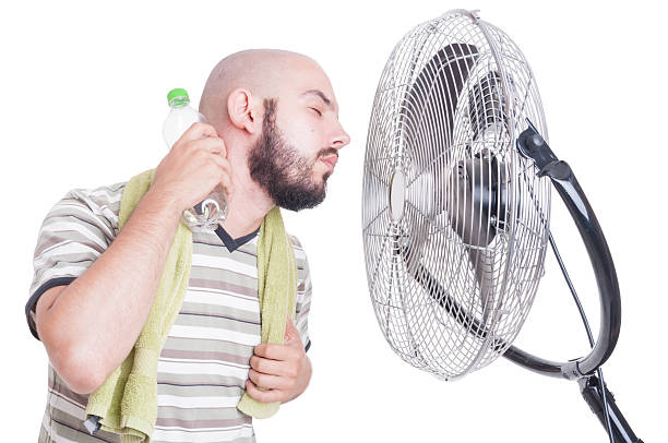 istock Man cooling his neck with cold water bottle and fan 483960482