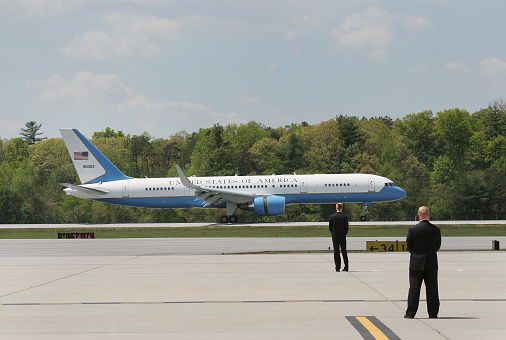 Asheville, North Carolina, USA - April 22, 2010: Secret Service agents watch as The United States Of America Air Force One Airplane carrying President Barack Obama lands on a runway at the Asheville Regional Airport in Asheville North Carolina on April 22, 2010.