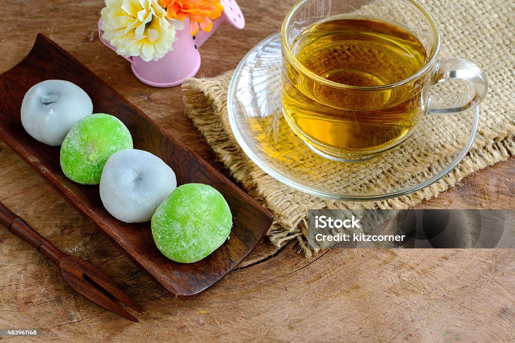 Daifuku greentea and sesame filling with cup of tea Daifuku greentea and sesame filling with cup of tea on wooden table 2015 Stock Photo