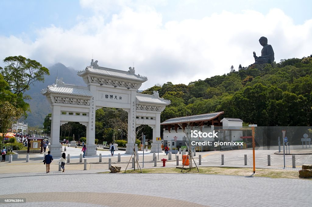 Gate at Po Lin monastery and Big Buddha, Hong Kong Tourists sightseeing the Po Lin Monastery, surrounded by the giant Tian Tan Buddha statue, located on Ngong Ping Plateau on Lantau Island, Hong Kong. Ngong Ping Stock Photo