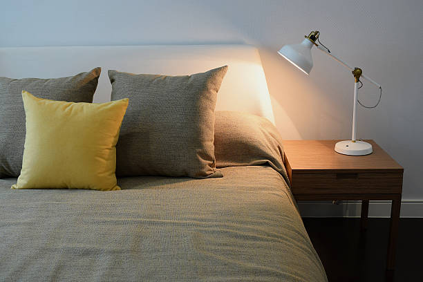 istock Cozy bedroom interior with pillows and reading lamp 483974710