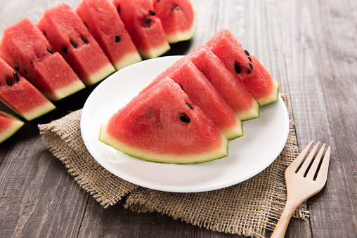Slices of fresh watermelon on wooden background.