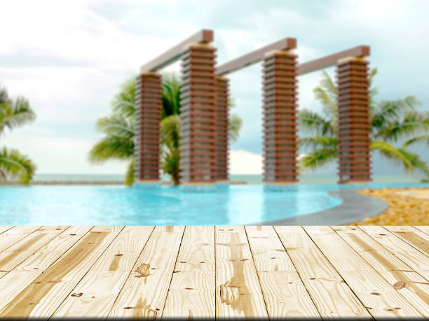 istock Wood table top on swimming pool blurred background 483975038