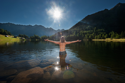 Austria,Styria,Mid adult woman standing in lake duisitzkar at schladming