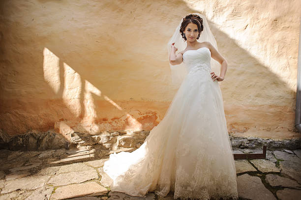 istock Bride wearing gorgeous wedding dress, posing against old building wall 483977814