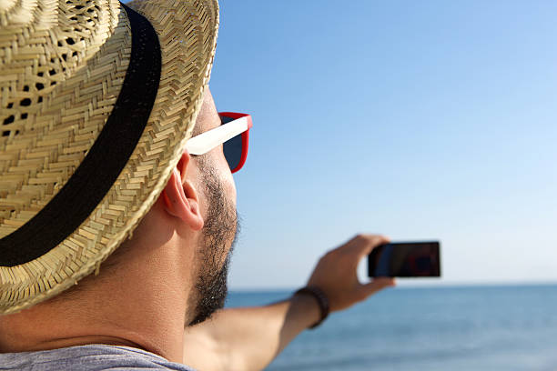 istock Man taking a selfie with cell phone at the sea 483984716