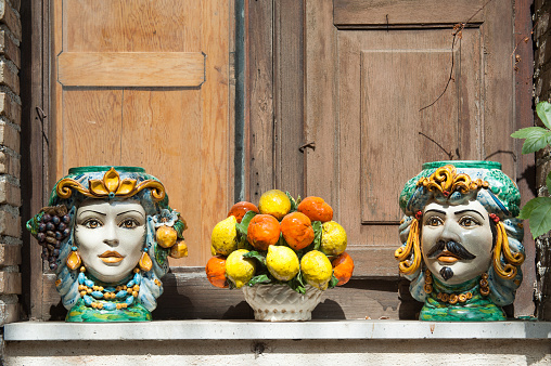 Typical ceramic vases and objects of sicilian craftsmanship used as ornaments on a window sill in Castelmola, Sicily