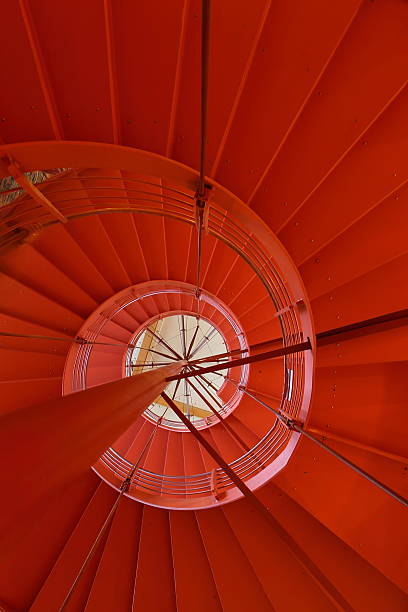 istock Orange round staircase in modern office building 483990371