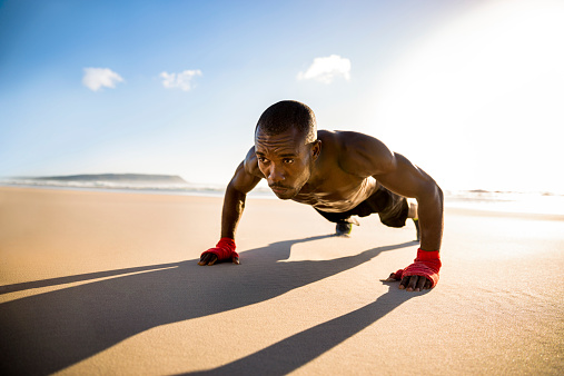 Man doing push ups at the beach