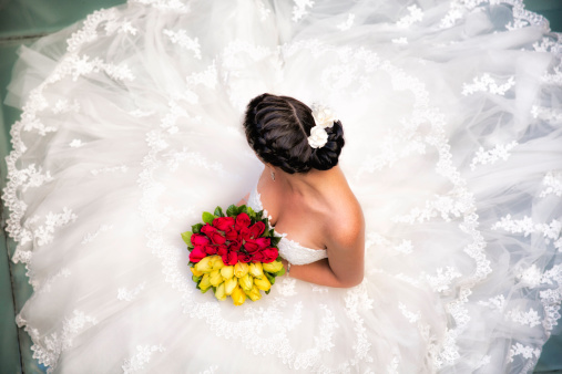 Relaxed sitting Bride with bouquet top down view