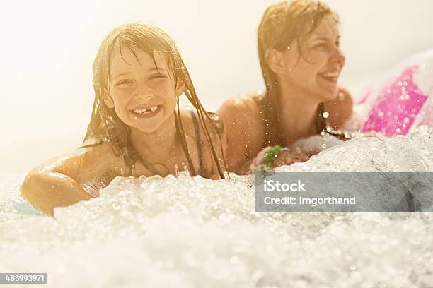 Daughter And Mother Having Fun In Sea Stock Photo - Download Image Now - 6-7 Years, Back Lit, Beach