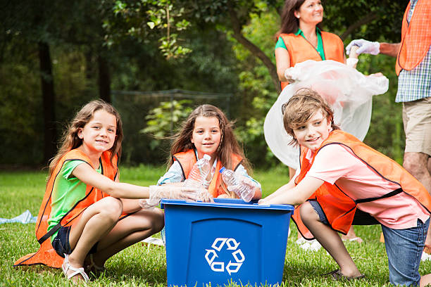 voluntarios: familia limpia sus community park. papelera de reciclaje. - recycling recycling symbol environmentalist people fotografías e imágenes de stock