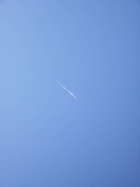 istock Vapor stripe of a plane on a clear blue sky 483994231