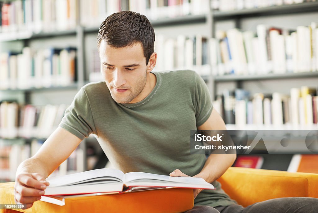 Masculino estudante estudar na biblioteca. - Foto de stock de Livro royalty-free