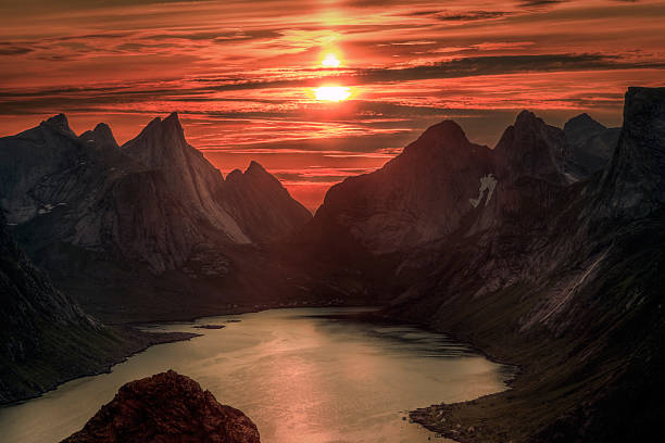 sol sobre reinebringen la medianoche. verano en la islas lofoten en noruega. - norway lofoten and vesteral islands sea mountain range fotografías e imágenes de stock