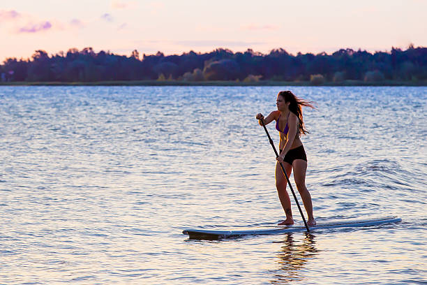 istock Female paddleboarding at sunrise 483997726