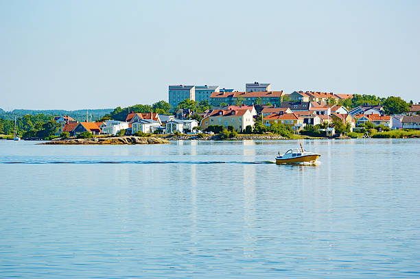 The Swedish city of Karlskrona is built on islands. Here is one view with a small boat cruising in the foreground. Calm water on this still morning.
