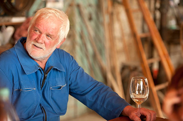 istock Senior Man with Beard Holding Glass of White Wine 484005052