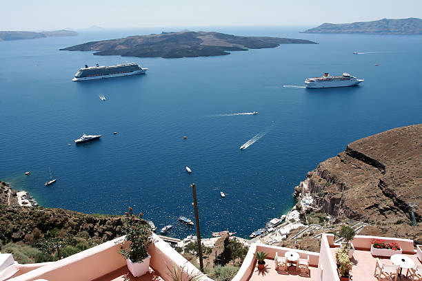 Santorini, Greece - June 25, 2015: Two large modern white cruise ships anchored off Thira, the main township on the greek island of Santorini. A wonderful example of the magnifincent vista on display on this wonderful island.