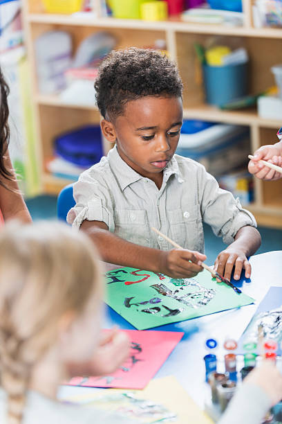 istock Little boy in art class painting a picture 484009872