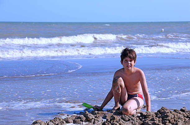 istock child plays on the beach with sand 484011030